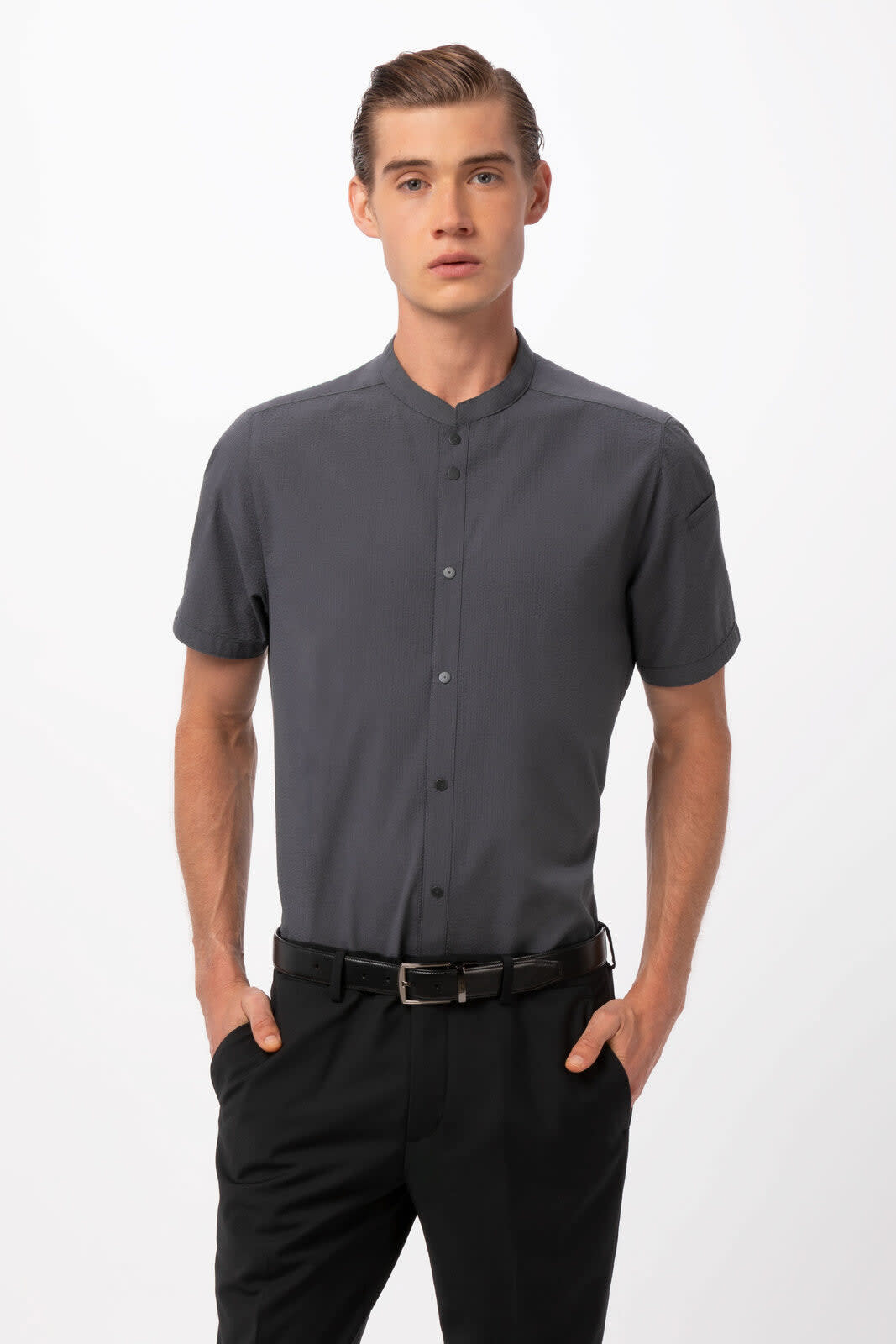 A short-sleeved, grey button-up shirt with a collar, paired with black trousers. The shirt has a logo.