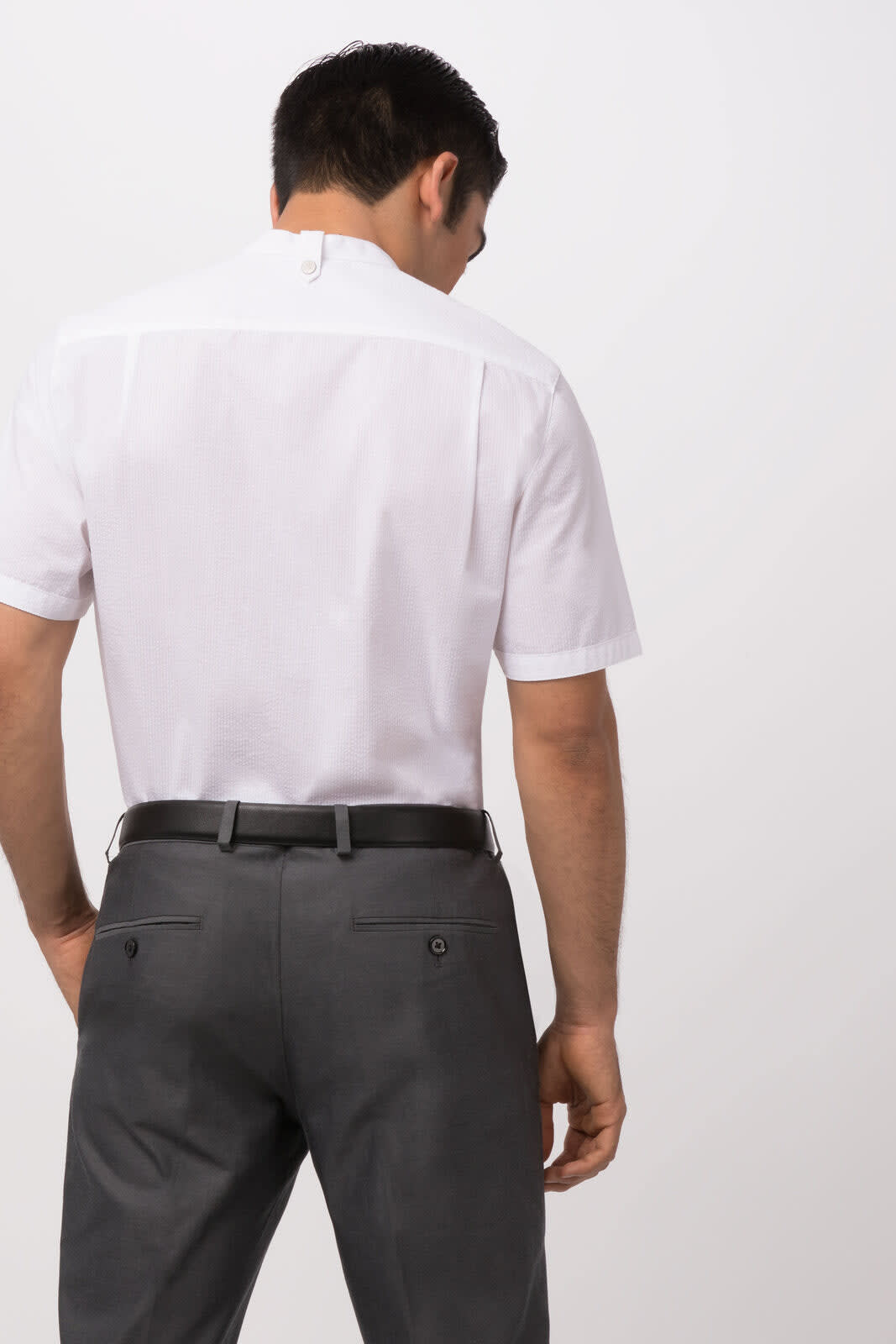 A white seersucker button-up shirt, displayed from the back, featuring a short collar and a logo.