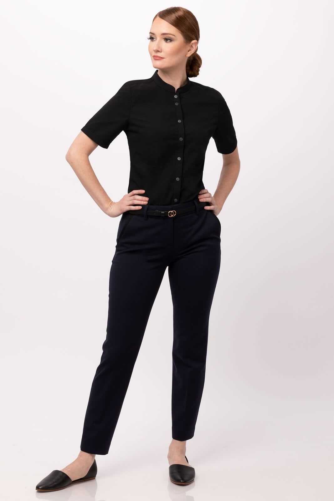 A black button-up shirt is worn with navy pants, featuring a sleek collar and short sleeves. The model poses confidently.