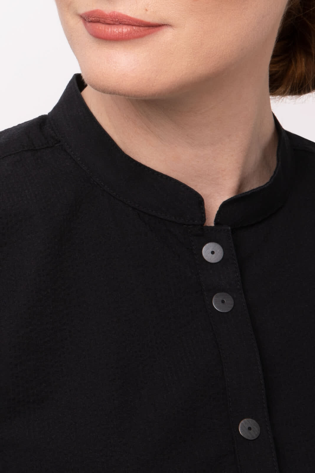A close-up of a black seersucker women's button-up shirt featuring a rounded collar and black buttons.