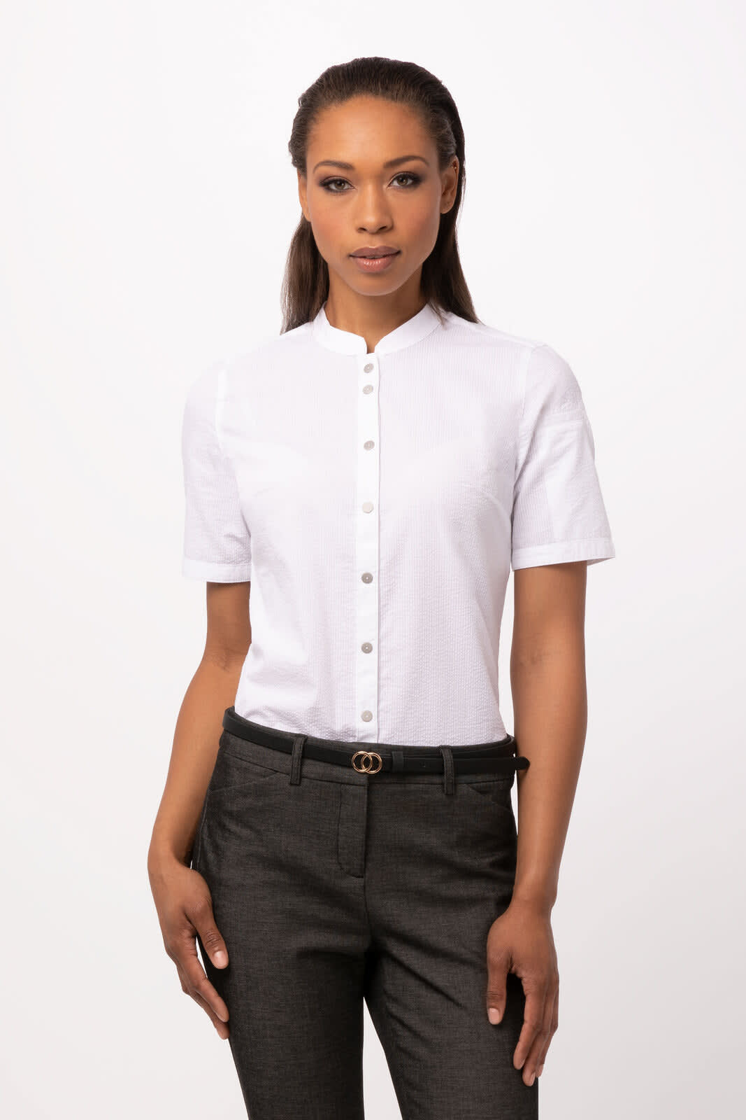 A white button-up women's shirt with a short collar, paired with dark trousers. The shirt features a logo.