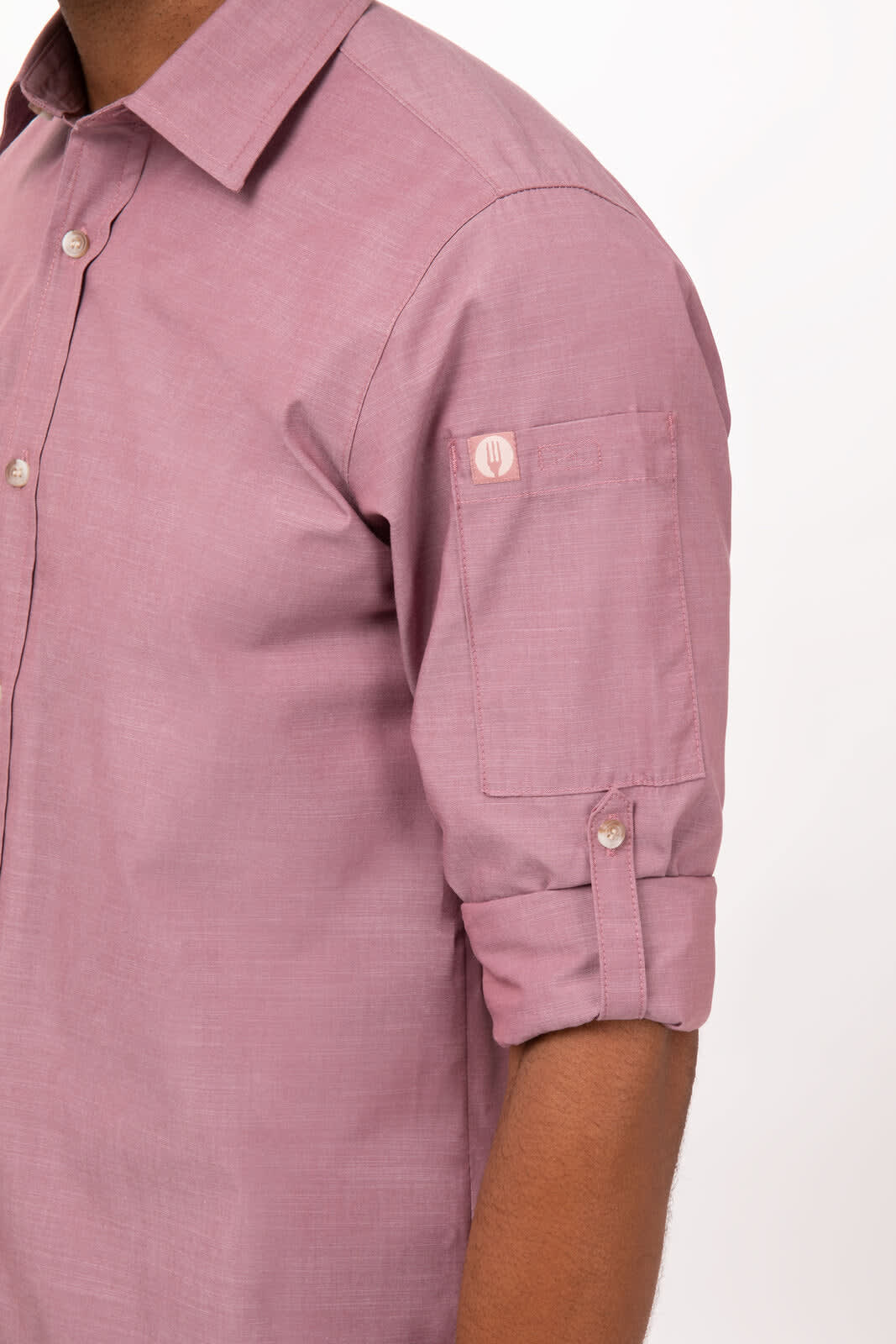 A chambray men's button-up shirt in a soft mauve colour, featuring rolled-up sleeves and a logo on the arm.