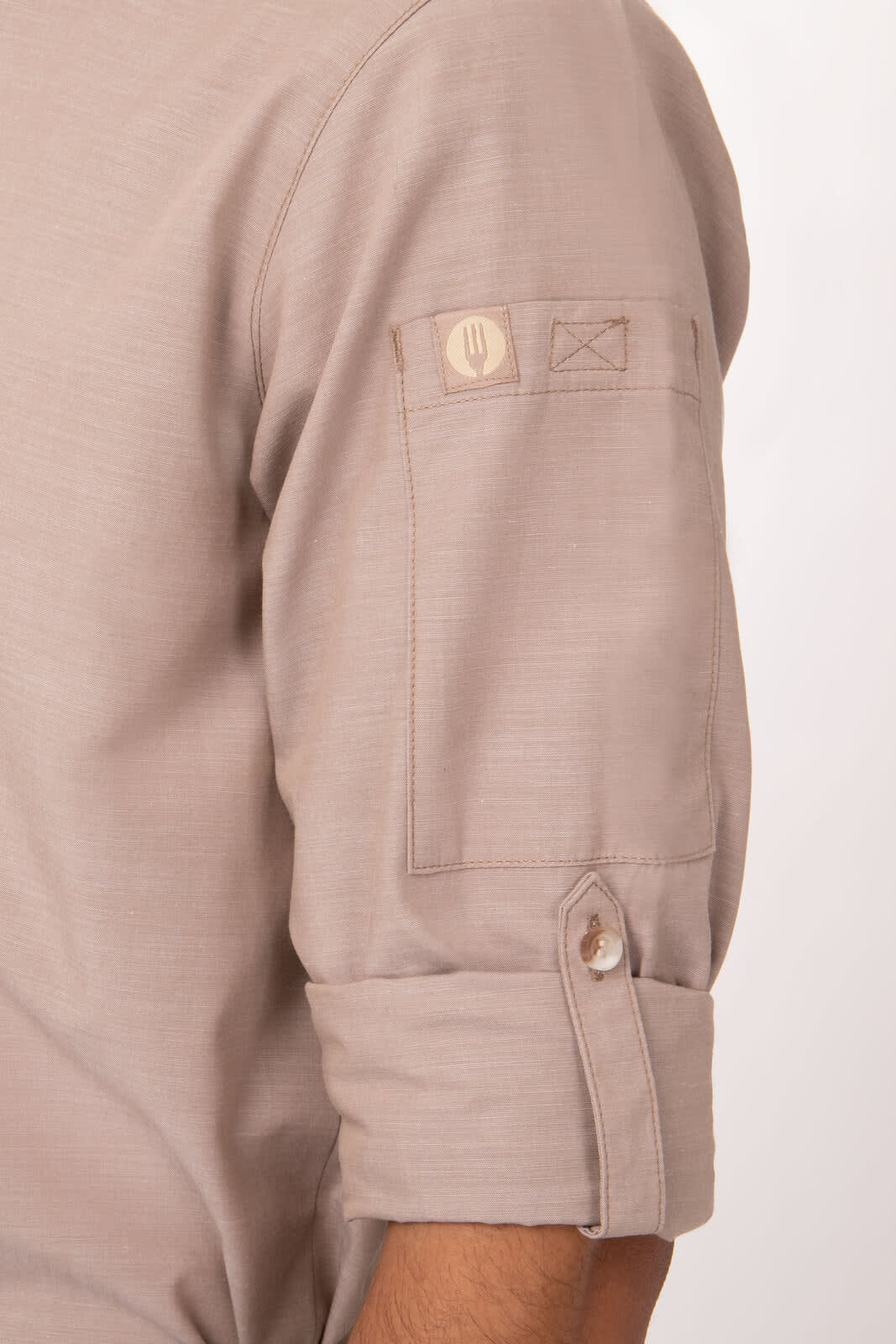 A men's chambray shirt in a light beige colour with rolled sleeves and a button detail on the arm.