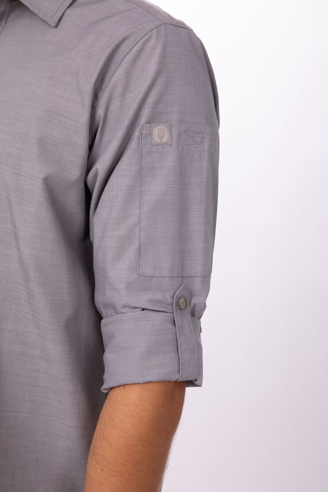 A grey chambray men's button-up shirt featuring rolled-up sleeves and a logo on the sleeve.