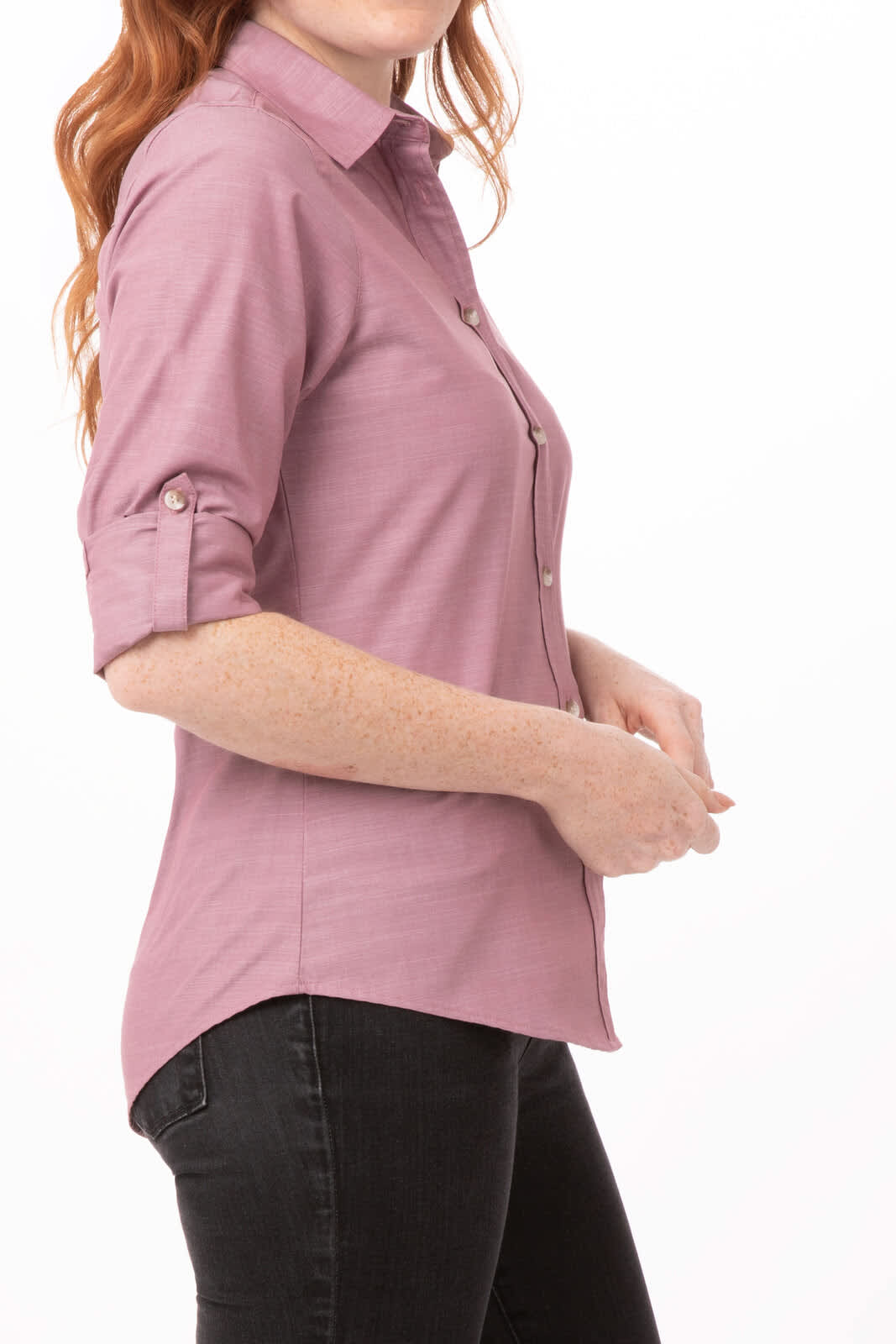 A pink chambray women's shirt with a button-down front and rolled-up sleeves, displayed on a model.