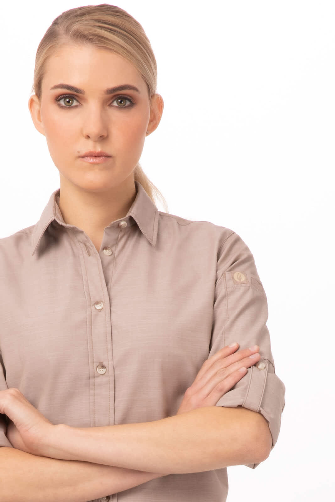 A beige chambray women's shirt featuring button details and rolled sleeves, displayed on a model with a neutral background.