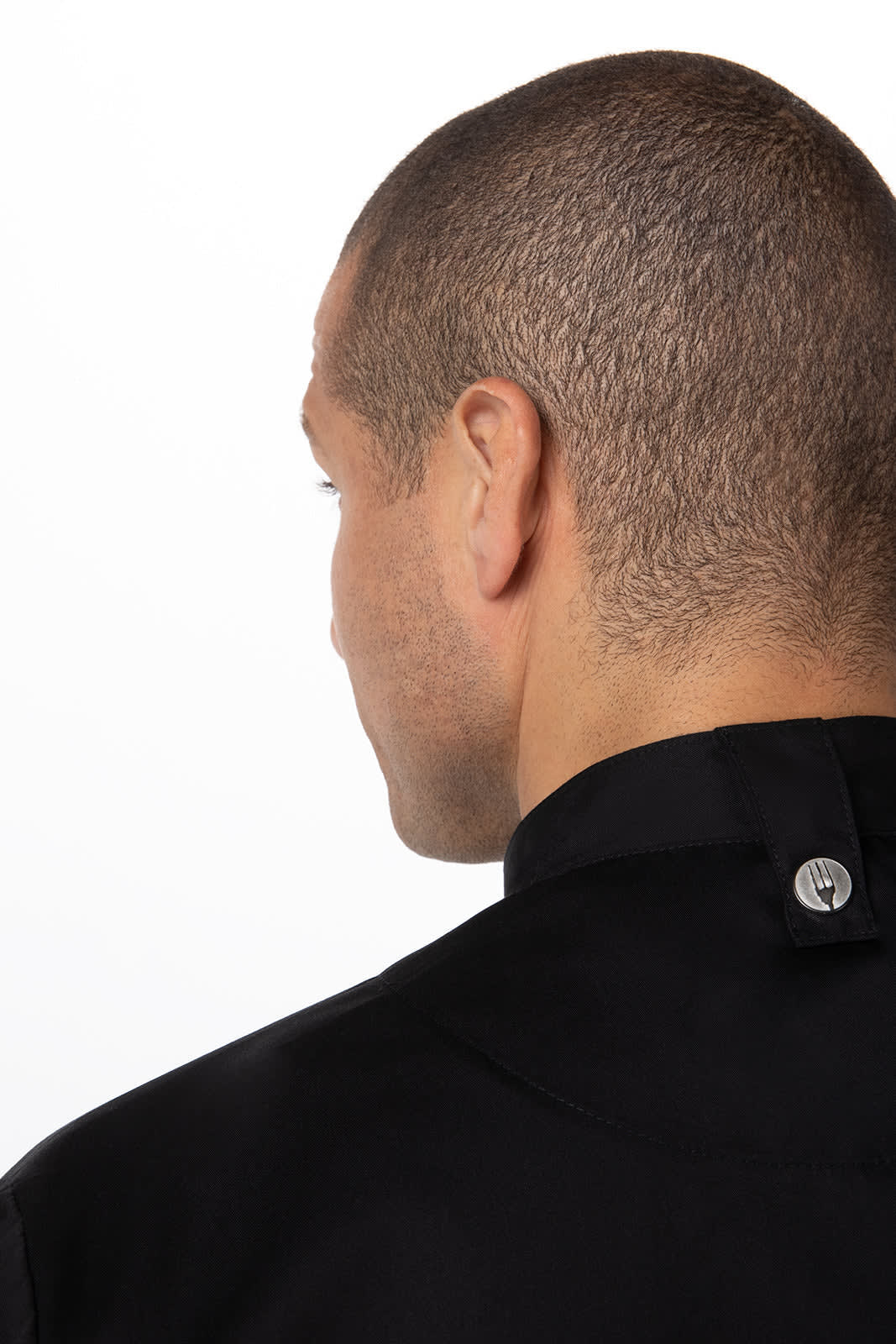A black chef jacket featuring a press stud closure at the back. The model's profile is visible.