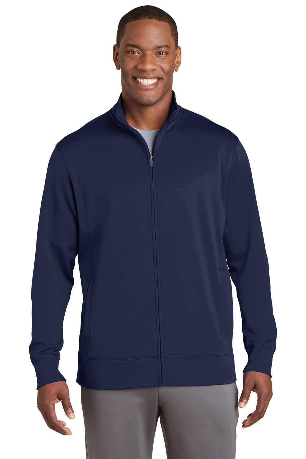 A full-zip jacket in navy blue, featuring a stand-up collar and a logo on the chest, worn by a smiling man.