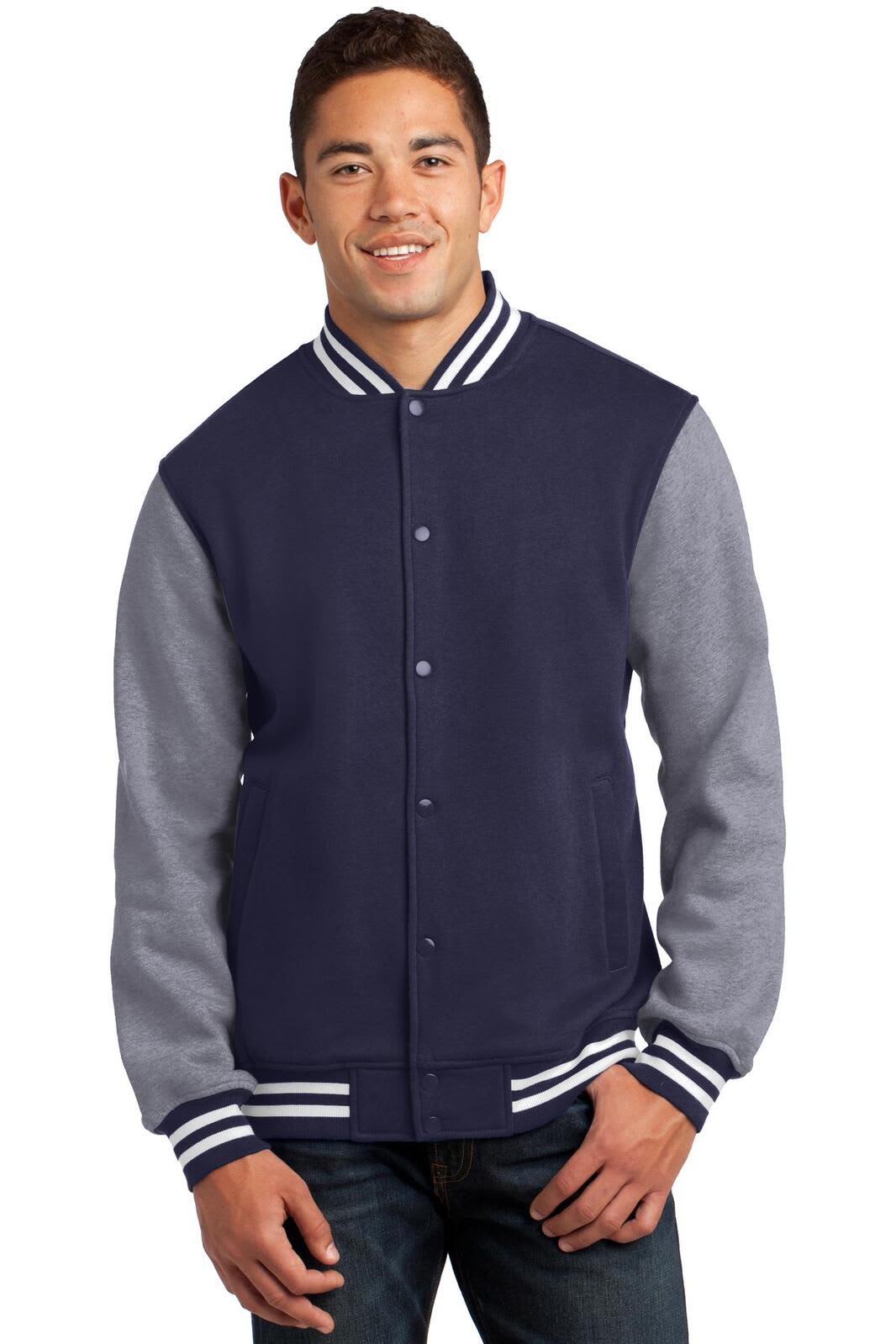 A man wears a navy and grey Sport-Tek Fleece Letterman Jacket, featuring a logo and striped detailing on the collar.