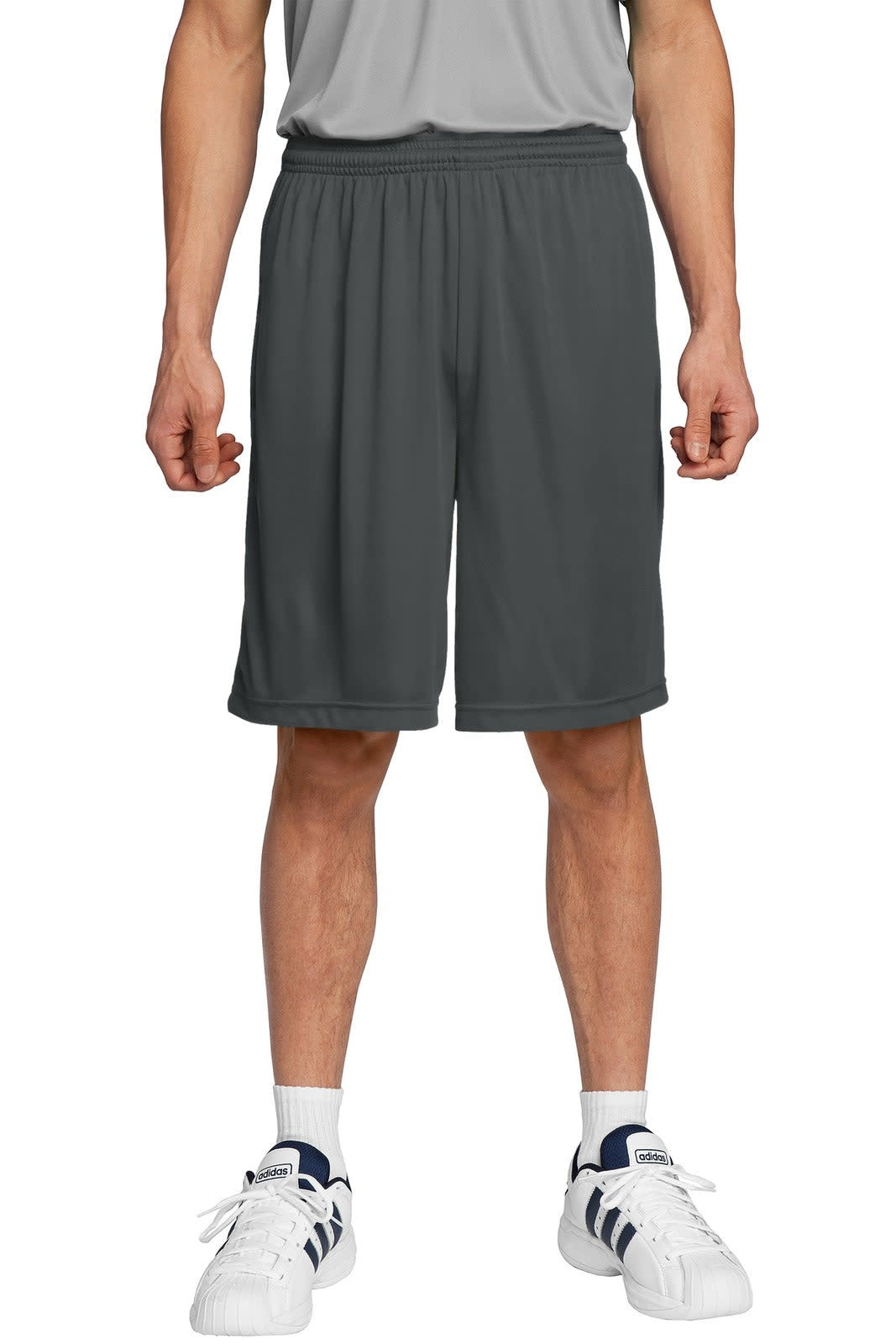 Dark grey sports shorts with an elastic waistband, displayed on a model wearing white sneakers. Features a branding logo.
