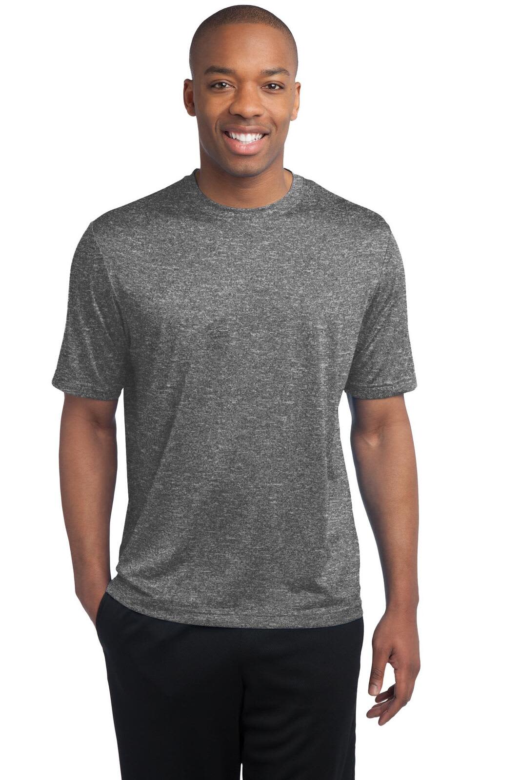 A man wearing a grey heathered T-shirt, smiling and standing with his hands at his sides. The shirt has a logo.
