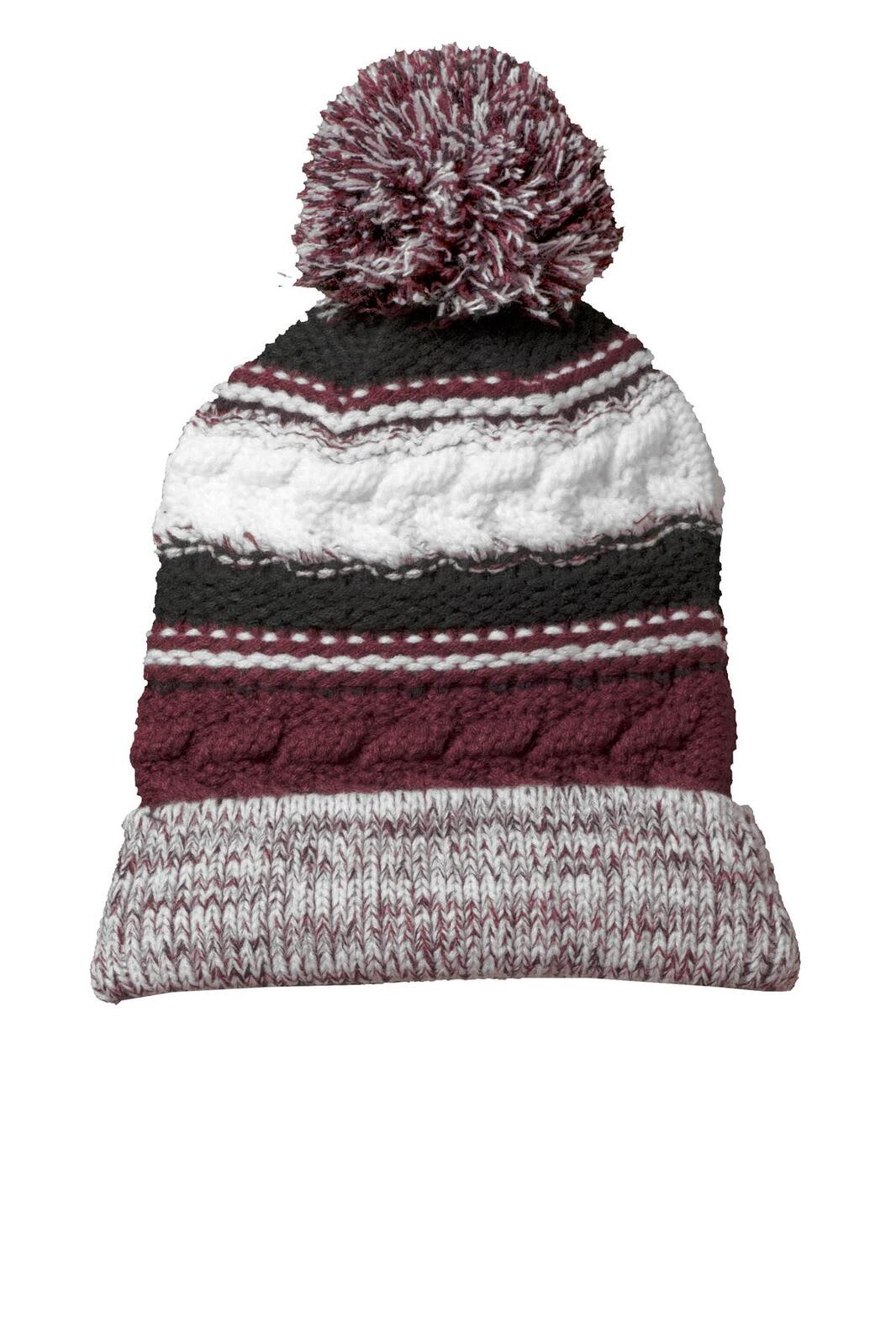 A knitted beanie in maroon, grey, and white, featuring a pom pom on top and a folded cuff.