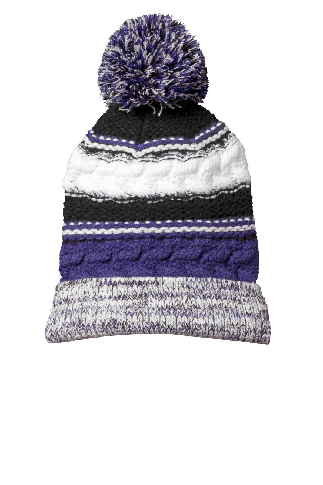 A multicoloured beanie in black, white, and purple featuring a pom pom on top and a textured design.