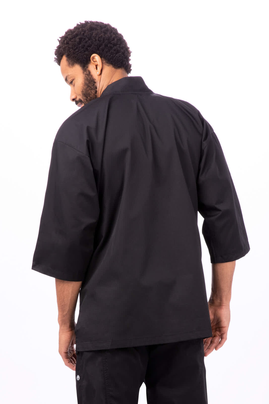 A black chef jacket with short sleeves, featuring a back view of a model. It has a sleek, minimalist design.