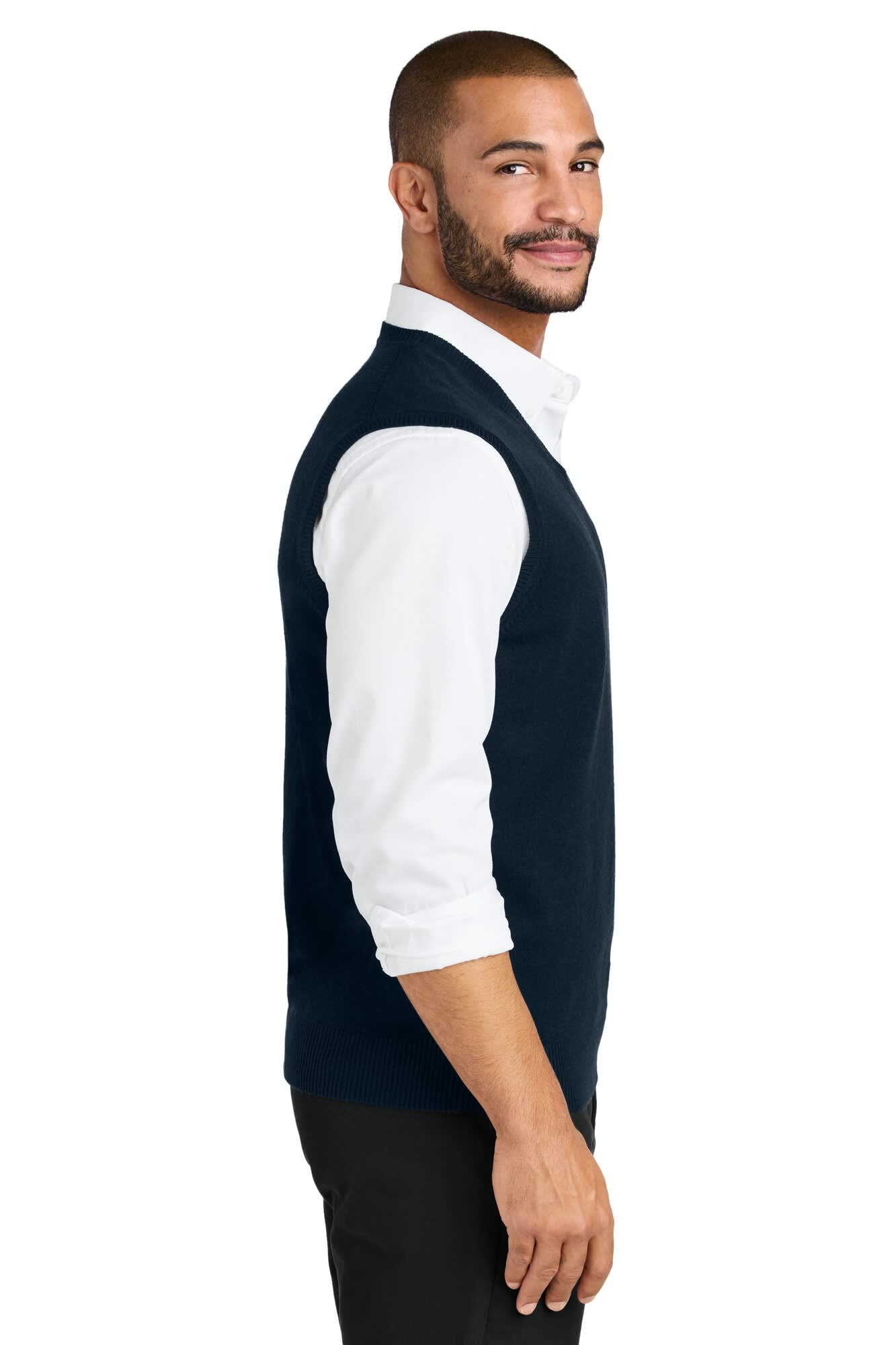 A navy sweater vest is worn over a white shirt, featuring a logo on the front. The model is smiling and facing sideways.