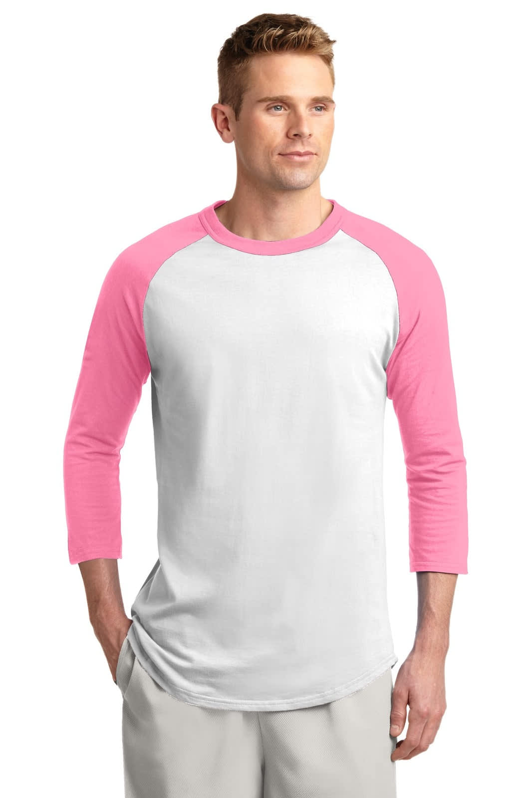 A man wearing a white and pink Sport-Tek Colorblock Raglan Jersey, featuring three-quarter sleeves and a logo.