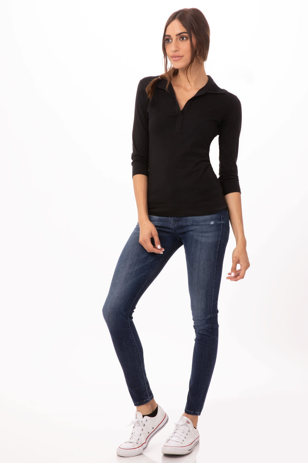 A black polo shirt displayed on a model, paired with blue jeans and white sneakers. The shirt features a logo.