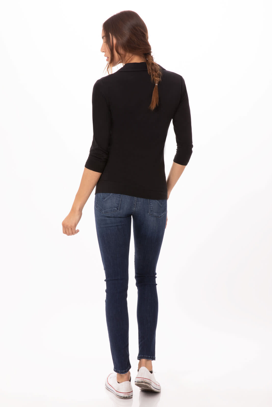 A woman wearing a black polo shirt and blue jeans, standing with her back to the camera. The shirt has a logo.