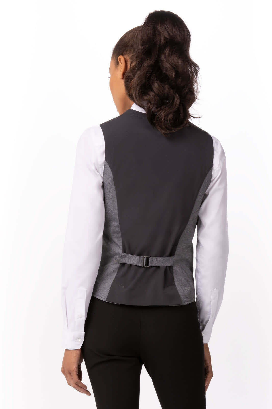 A grey women's vest with a structured design, featuring a back strap detail. The model is wearing a white long-sleeve shirt underneath.