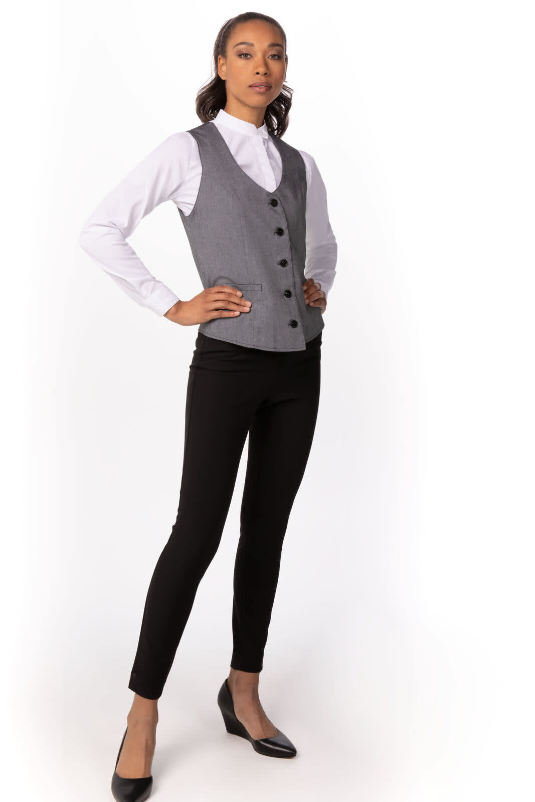 A grey women's vest with black buttons, paired with a white shirt and black pants, featuring a model standing confidently.