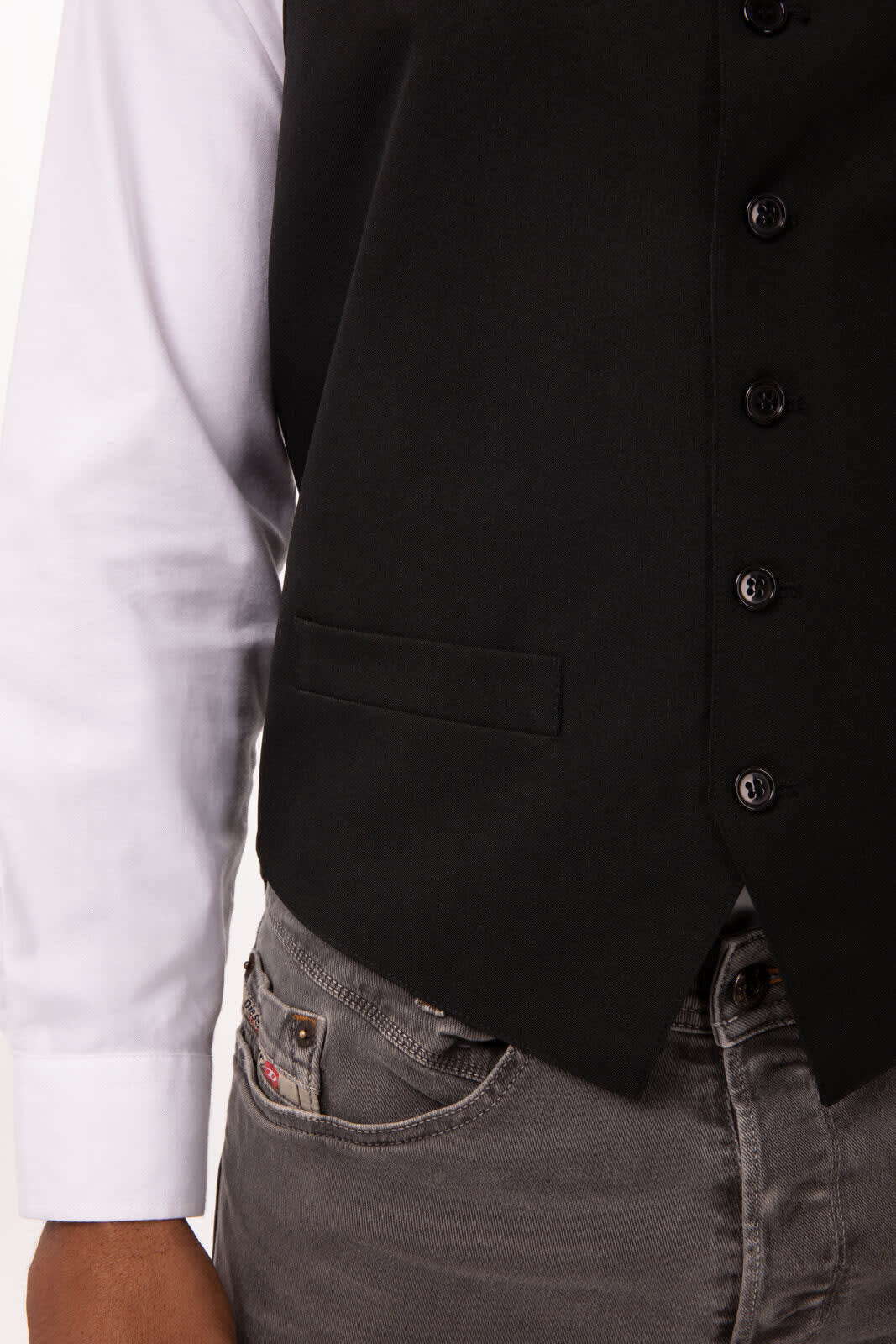 A black men's vest with buttons, paired with a white long-sleeve shirt and grey trousers.