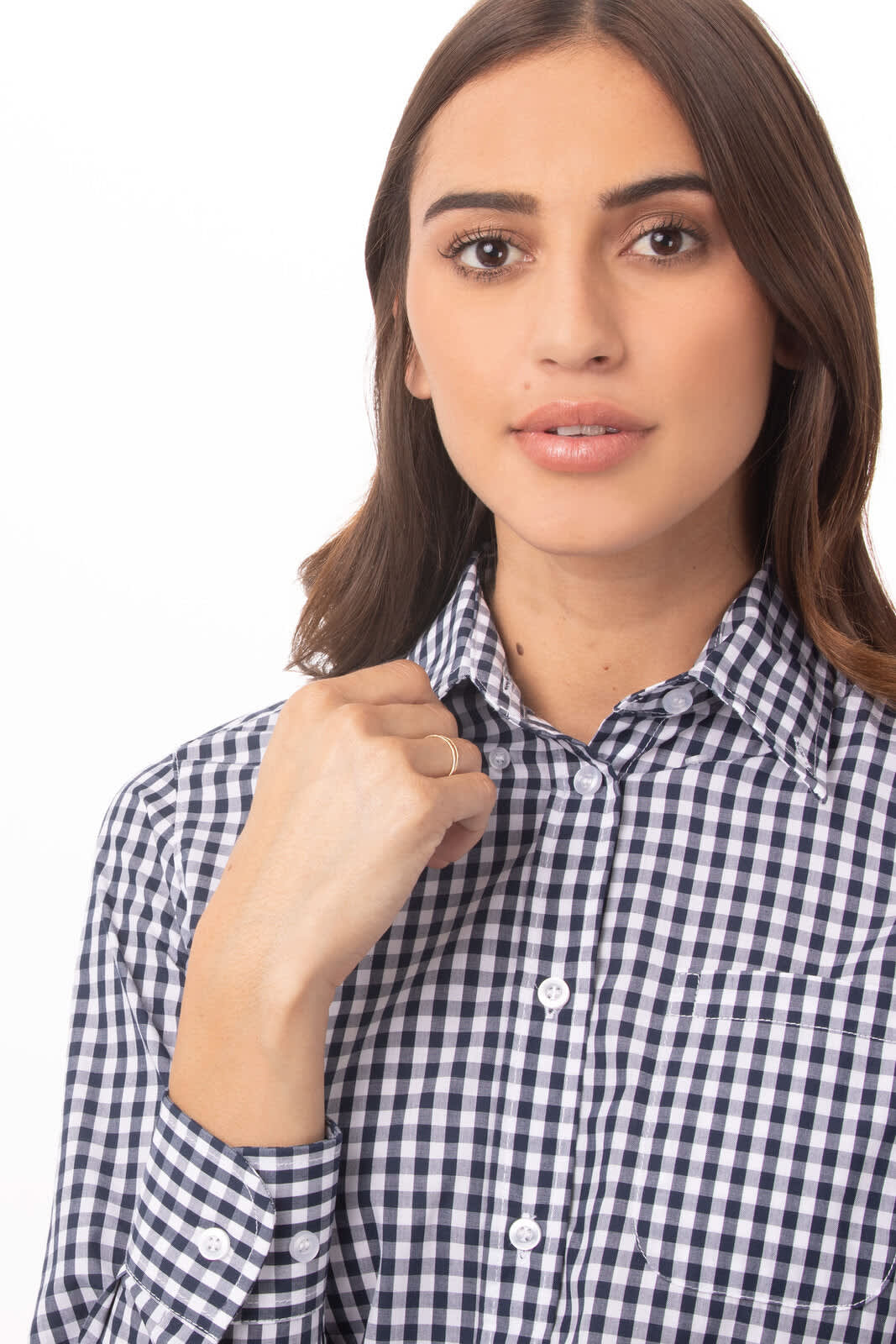 A close-up of a woman wearing a navy and white gingham button-up shirt with a collar and a pocket.