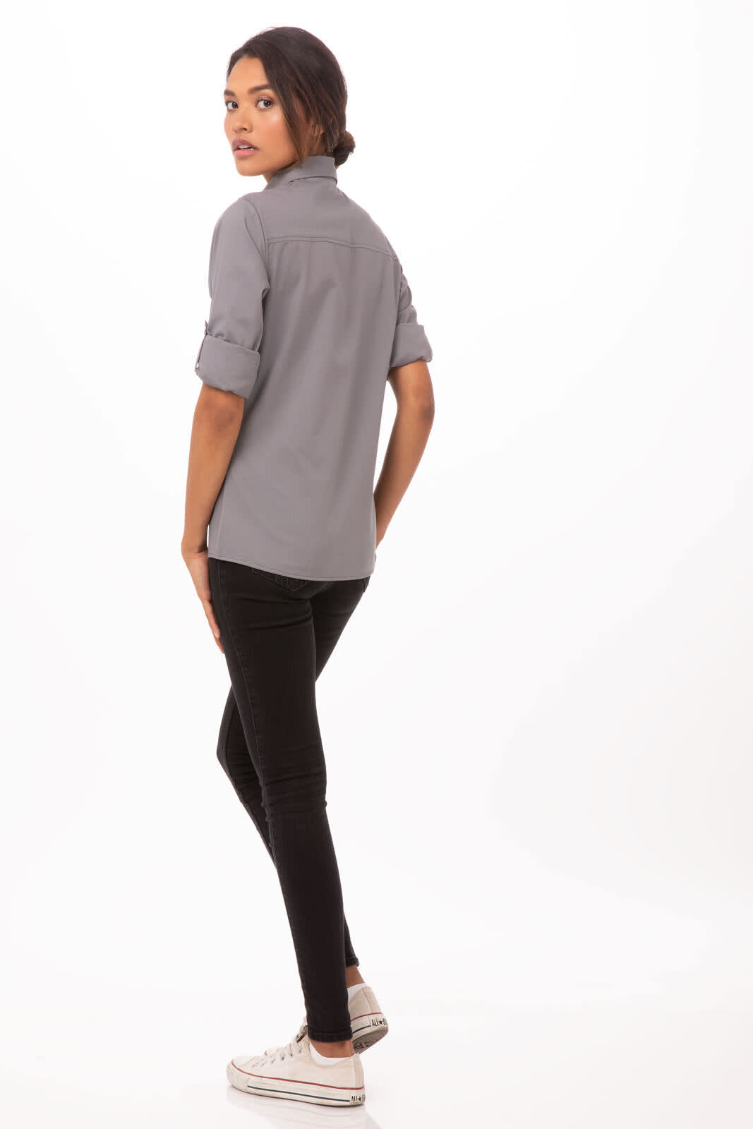 A grey button-up women's shirt with rolled sleeves, paired with black pants and sneakers. The model stands with her back to the camera.