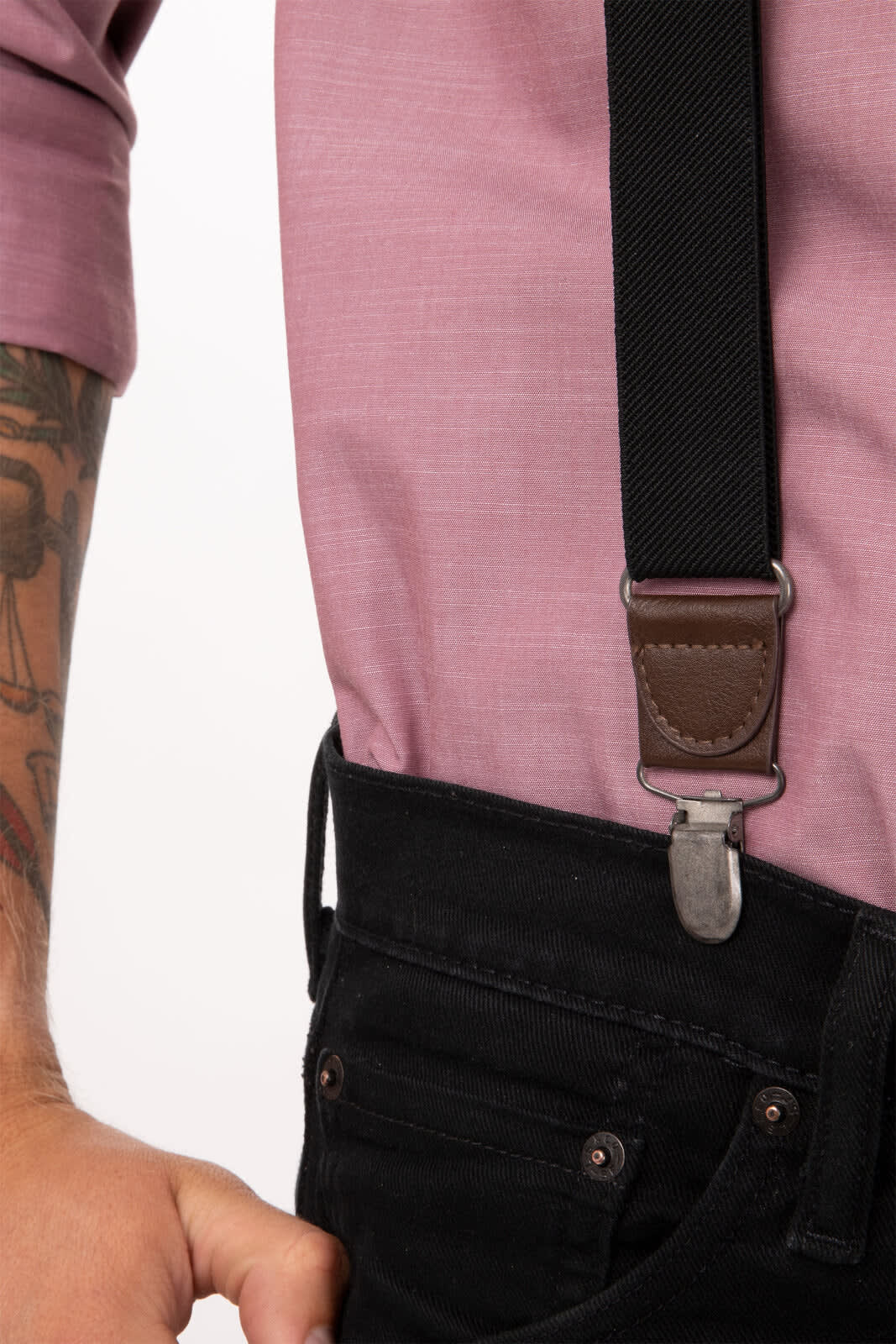 Black pant suspenders with metal clips, worn with a pink shirt and black jeans.