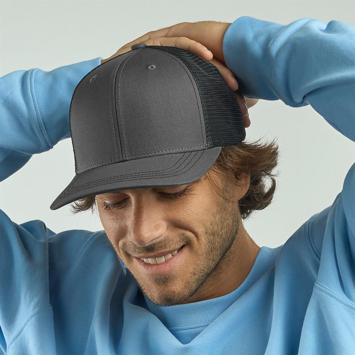 Sonic-S Organic/Recycled Trucker LE-A2410 A grey trucker cap with a mesh back, worn by a smiling man in a light blue sweatshirt.