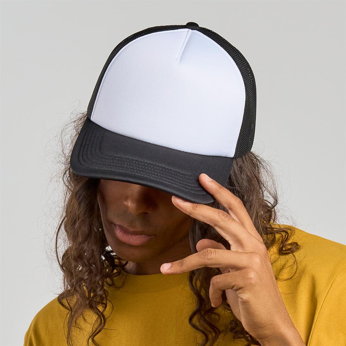 Rapper-S Recycled Polyester LE-A2510 A black and white trucker cap featuring a flat brim and mesh back, worn by a person with long, curly hair.