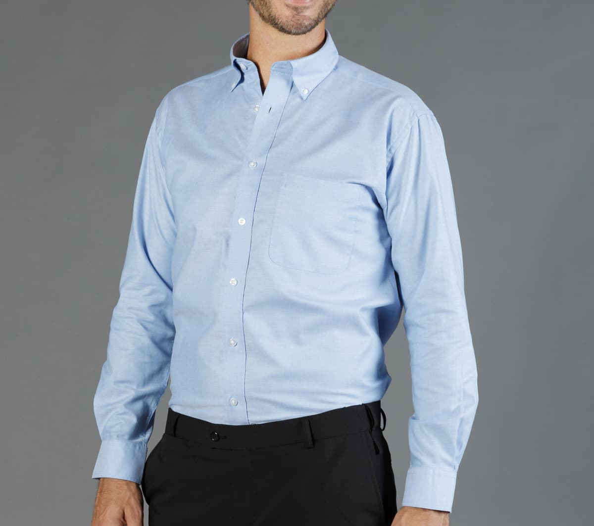 A light blue button-up shirt with a pocket, featuring a collar and long sleeves.
