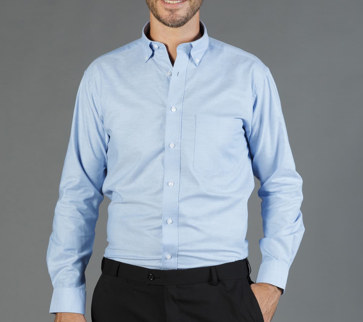 A light blue button-up shirt with a collar and a chest pocket, featuring a branded logo.