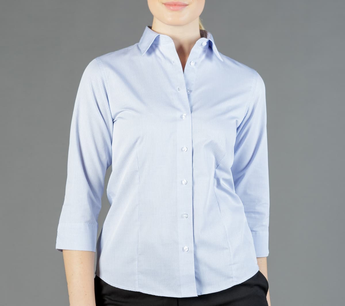 A light blue, long-sleeved shirt with a collar and buttons, featuring a fitted design. It has a branding logo.