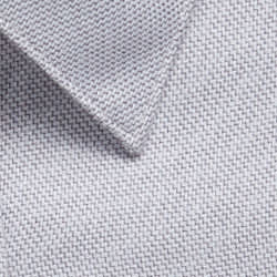 A close-up of a light grey woven fabric with a textured surface, featuring a collar edge and a logo.