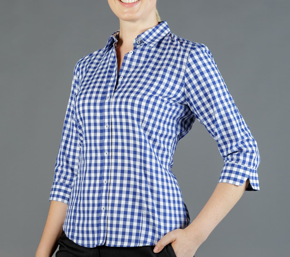 A blue and white checked button-up shirt with three-quarter sleeves, displayed on a model against a grey background.