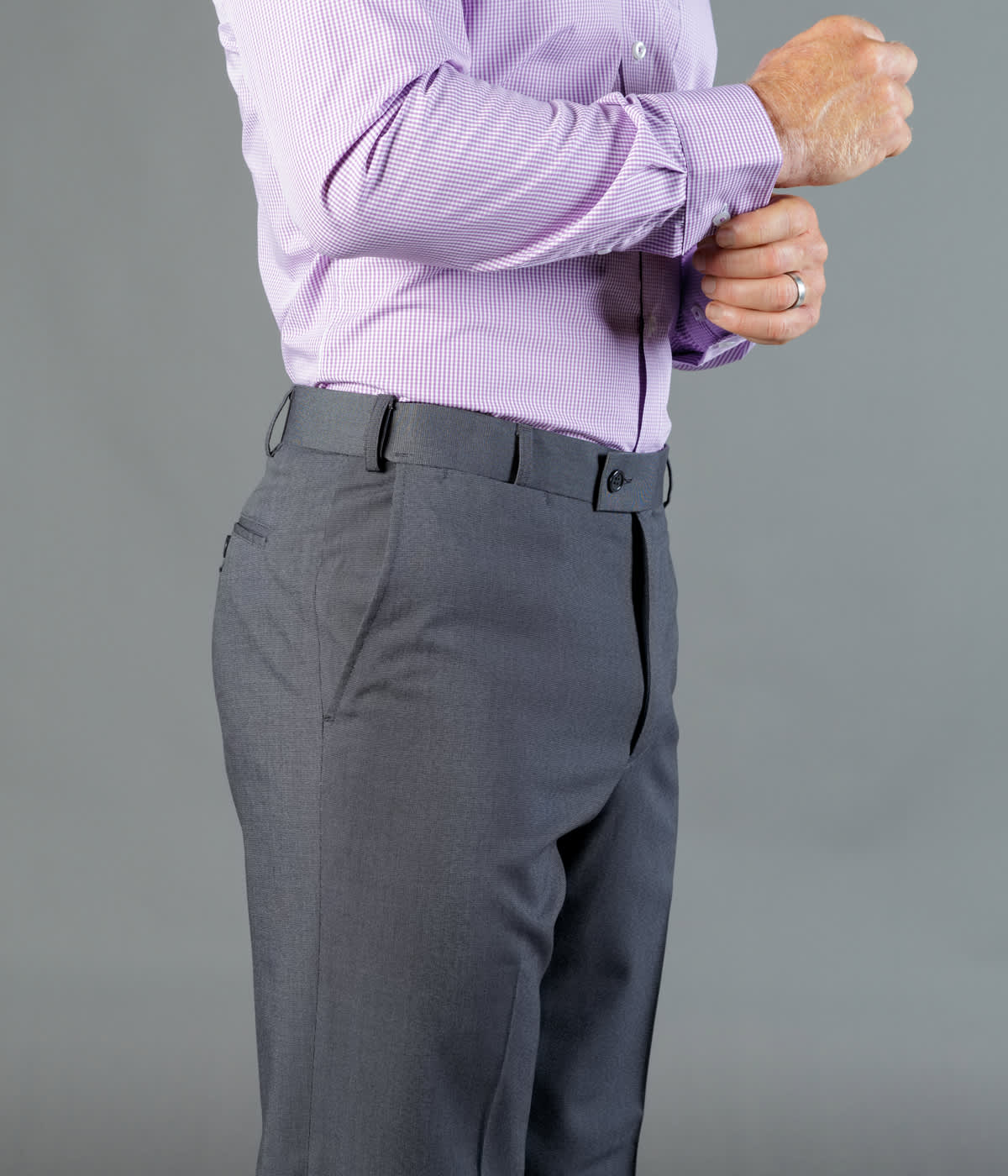 Elliot Pants in dark grey, featuring a tailored fit with belt loops, styled with a light purple shirt.