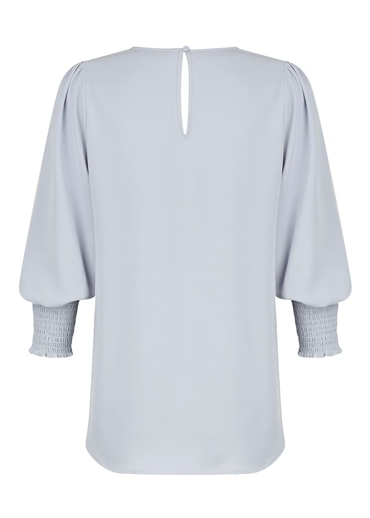 A light grey shirt featuring a keyhole back and smocked sleeves, with a smooth, flowing design.