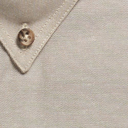 A close-up of a beige work shirt featuring a collar and a button. The fabric has a textured finish.