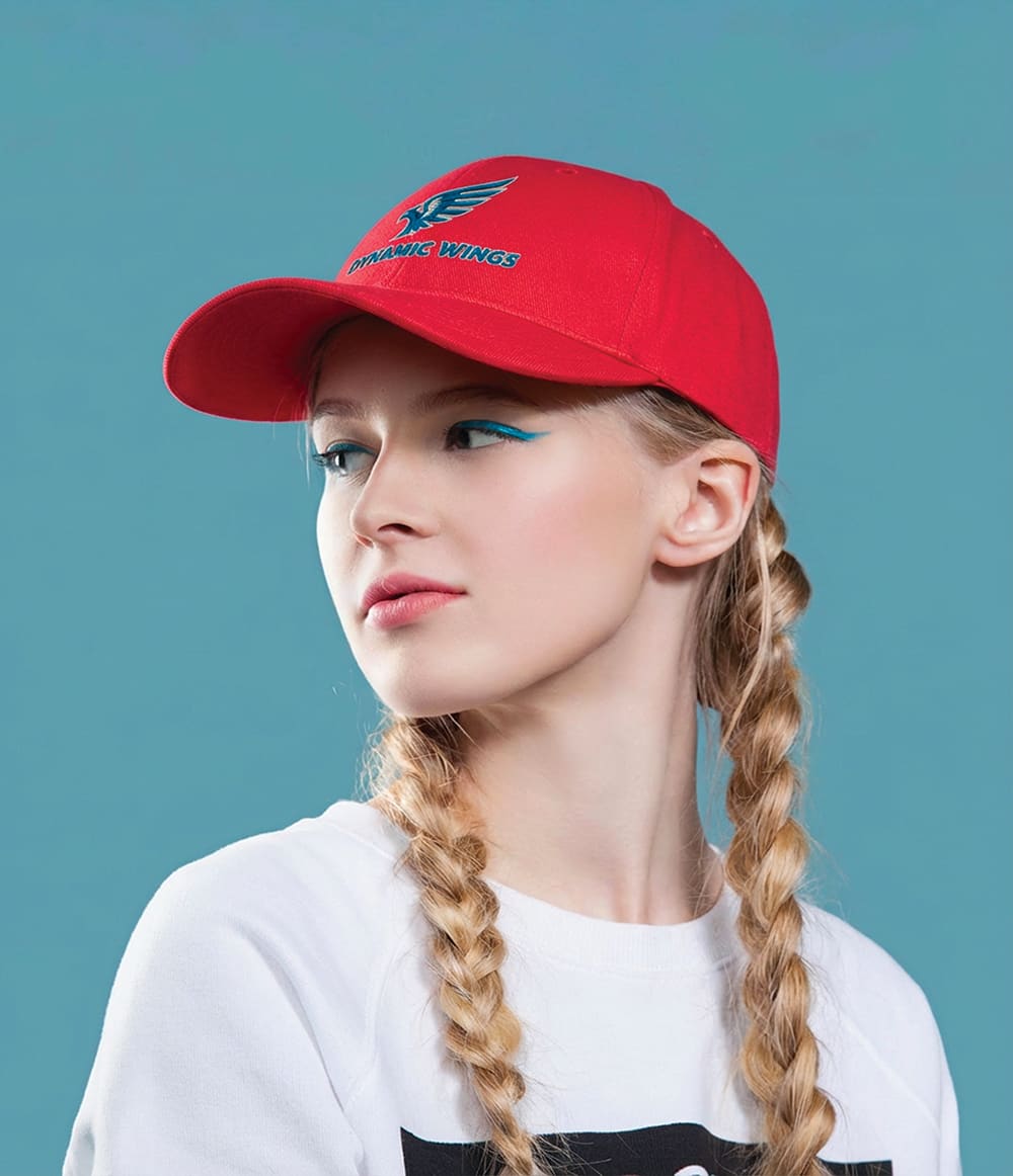 Cotton Twill Cap with Buckle HE-3964 A red cotton twill cap with a buckle, featuring a logo, worn by a model with braided hair against a blue background.