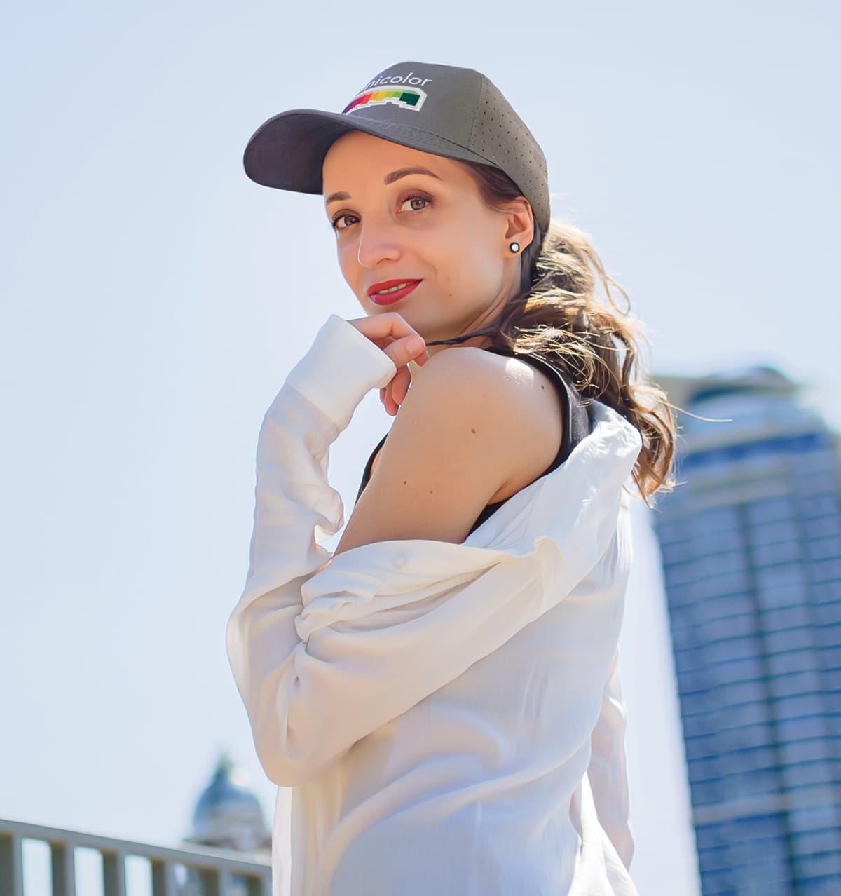 Breathable Poly Twill with circle perforations HE-3976 A woman poses wearing a black cap with circle perforations, showcasing a stylish outdoor look.