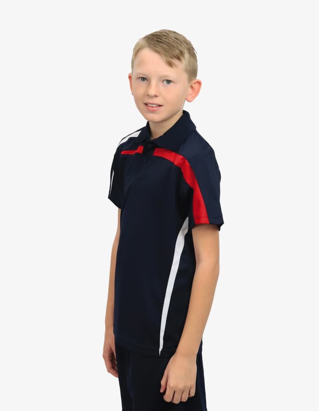 A boy wearing a navy blue polo shirt with red and white accents and a logo on the chest.