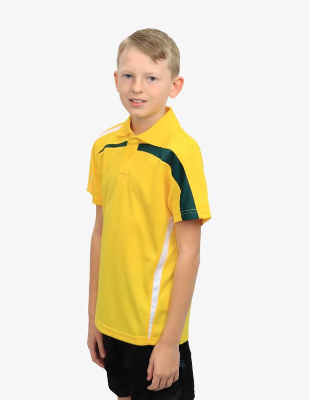 A young boy wearing a bright yellow polo shirt with green accents and white details, alongside black shorts.