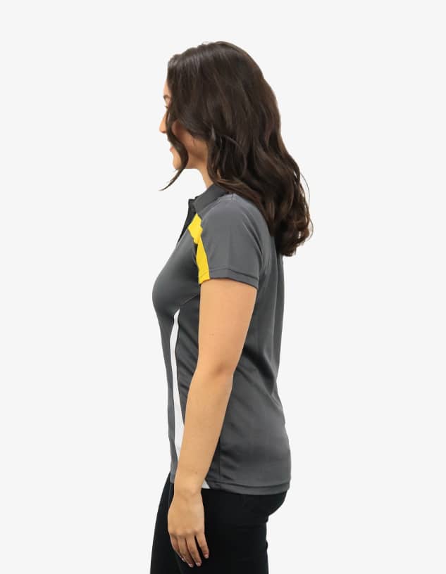 A grey polo shirt with yellow accents, featuring a logo on the chest. The shirt is modelled by a woman from the side.