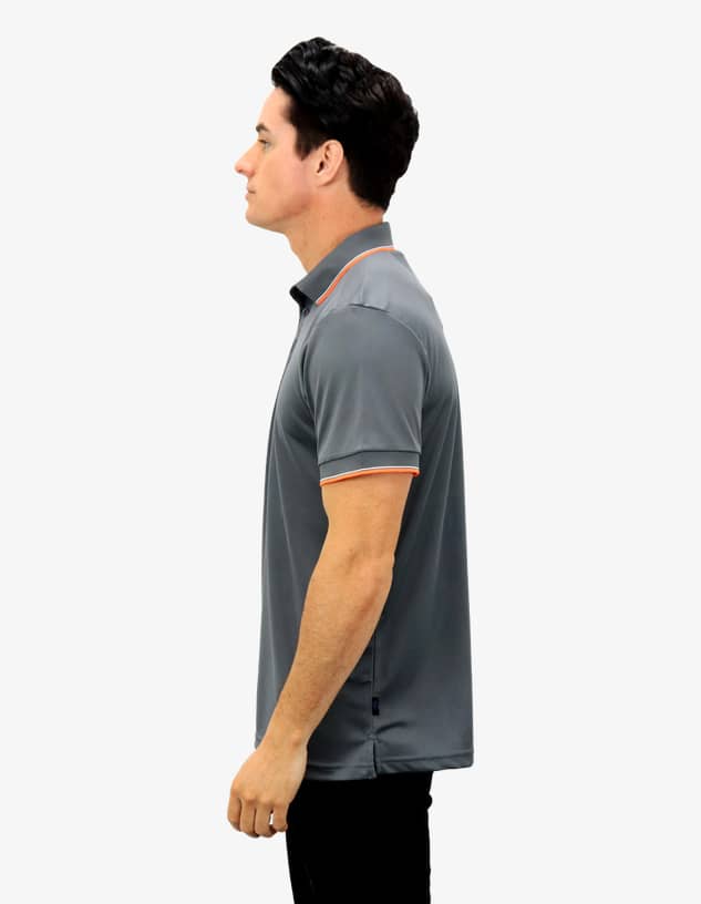 A grey polo shirt with orange accents, featuring a collar and short sleeves, on a model from the side.
