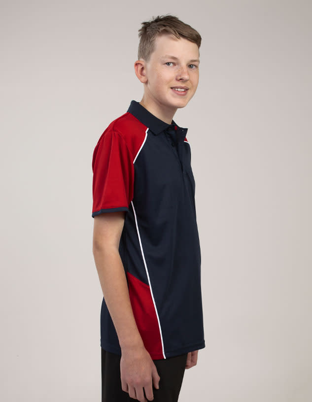 A young person is wearing a navy blue polo shirt with red accents and white piping, featuring a logo on the chest.