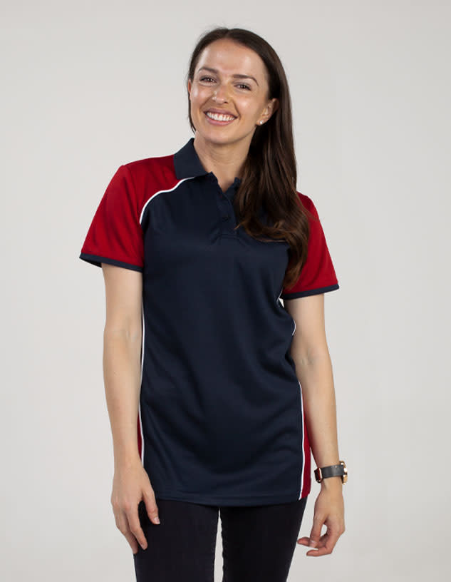 A woman is wearing a navy blue and red polo shirt with contrasting white accents and a logo.