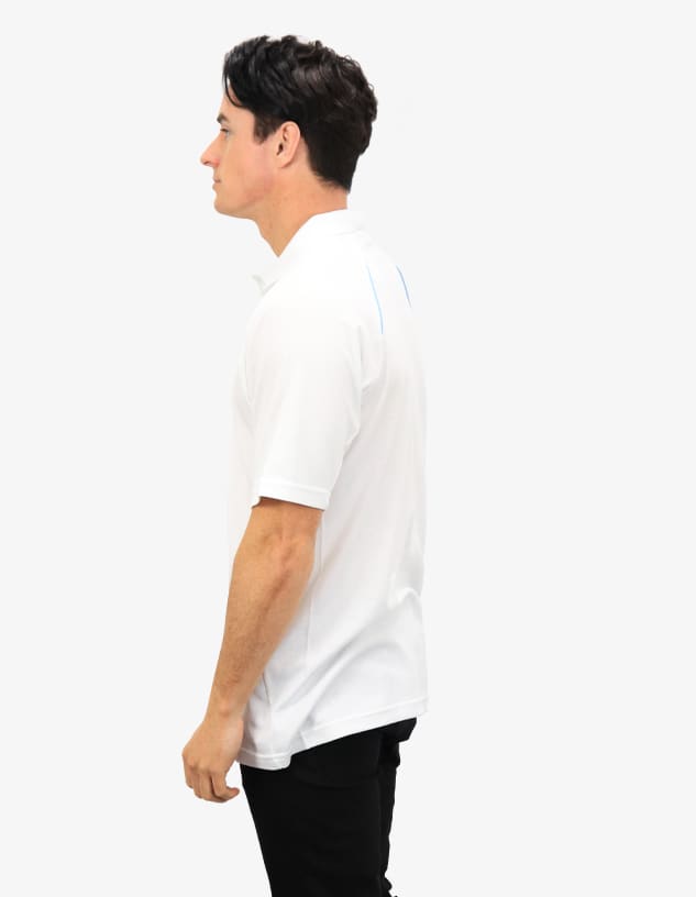 A white polo shirt featuring a branding logo, shown from the side on a model.
