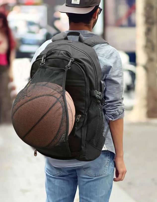 A backpack in black with a basketball visibly secured in a mesh pocket on the back.