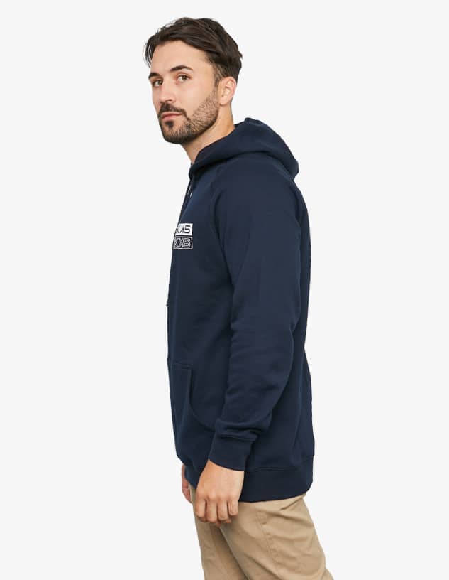 A navy hoodie featuring a front pocket and a logo. The model is posed in profile, looking to the side.