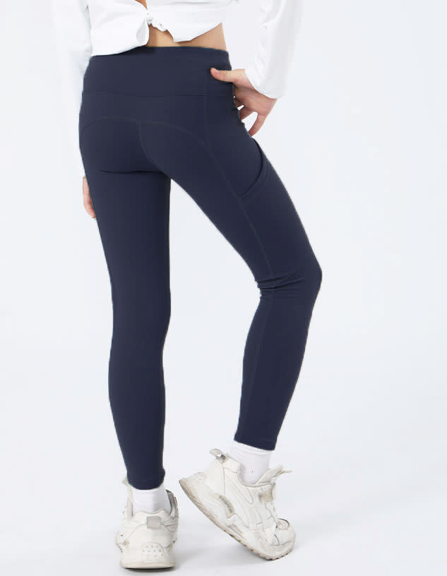Navy girl's leggings with a fitted design, featuring a pocket and paired with white sneakers.